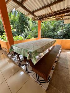 a table on a porch with a green table cloth on it at Casa da Mata in Ubatuba