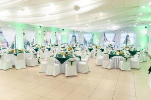 a large banquet hall with tables and white chairs at Vistula Hotel in Świecie +47 photos