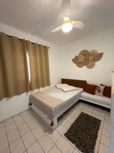 a bedroom with a bed and a ceiling fan at Apartamento Boqueirão Ilha Comprida Tati Ortega in Ilha Comprida