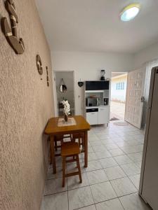a dining room with a table and a kitchen at Apartamento Boqueirão Ilha Comprida Tati Ortega in Ilha Comprida