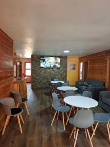 a waiting room with tables and chairs and a tv at Habitación privada en Coñaripe de 1 Cama in Coñaripe