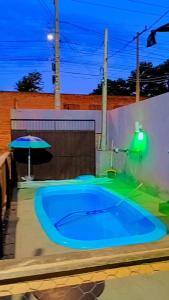 a large blue swimming pool with an umbrella at Pousada navarro in São Gabriel +10 photos