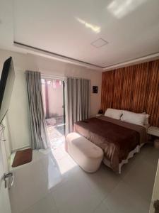 a bedroom with a bed and a sliding glass door at Casa 2 quarto em condomínio in Camaçari +13 photos