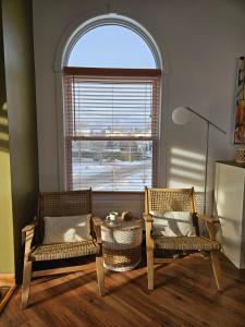 zwei Stühle und ein Tisch in einem Zimmer mit Fenster in der Unterkunft Condo ÉVASION in Magog-Orford