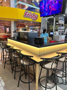 a restaurant with a bar with chairs and a tv at Apartaestudio con cocina dentro centro comercial in Cartago