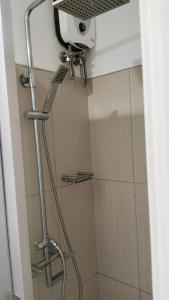 a shower with a shower head in a bathroom at Nygel Staycation at Shell Residences in Sampong +11 photos