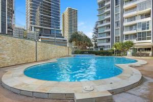 a large swimming pool with buildings in the background at Golden Arcade - Views Games Vibes in Gold Coast