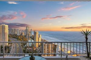 a view of a city and the ocean at sunset at Golden Arcade - Views Games Vibes in Gold Coast