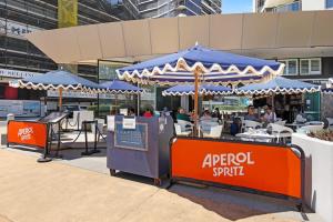 a restaurant with an umbrella and people sitting at tables at Golden Arcade - Views Games Vibes in Gold Coast +24 photos
