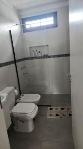 a bathroom with a white toilet and a sink at Departamento macrocentro I, espacioso Río Cuarto in Río Cuarto +18 photos