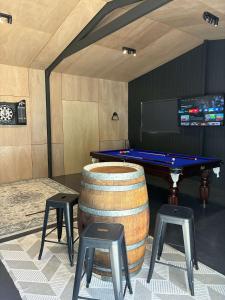 a room with a pool table and two stools at Sunset Views in Wellington East