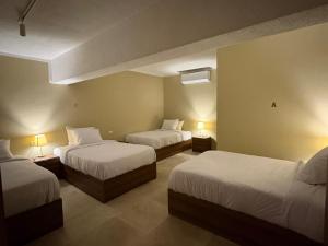 a hotel room with two beds and two lamps at The Fit Stop Hostel in Hurghada +101 photos