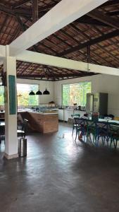 a large room with tables and a kitchen in a building at Pousada Villa Felicidade in Guarapari