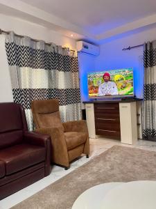 a living room with a couch and a flat screen tv at Tranquil Stay Tunereng in Tujering