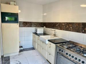 a kitchen with a sink and a stove top oven at Tranquil Stay Tunereng in Tujering