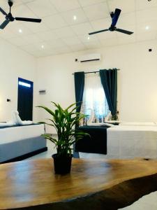a bedroom with a bed and a plant on a table at Vimanra Udawalawa in Udawalawe