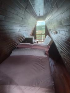 a bedroom with a bed with a wooden head board at Chalé toca do tigre in Ponta Grossa