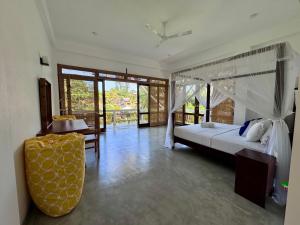 a bedroom with a bed and a table and chairs at CoCo-SuRf-House, Luxury among palms in Hikkaduwa