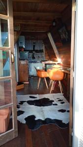 a room with a kitchen with a table and a rug at Chalé toca do tigre in Ponta Grossa +11 photos