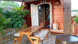a patio with a wooden table and chairs on a house at Chalé toca do tigre in Ponta Grossa
