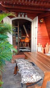 a patio with a wooden table and chairs and a piano at Chalé toca do tigre in Ponta Grossa