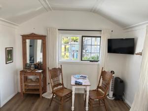 a living room with a table and chairs and a window at The Artists Cottage Waterfront Hideaway in Strahan