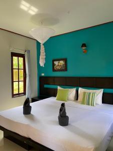 a large white bed in a room with a blue wall at Sonya Kohlanta in Ko Lanta