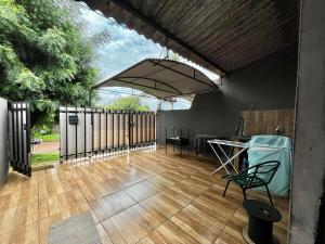 acovered patio with a table and chairs on a wooden floor at Loft D Mobiliado, individual com ar condicionado e garagem privada in Dourados