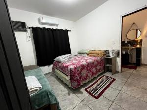 a bedroom with a bed and a black curtain at Loft D Mobiliado, individual com ar condicionado e garagem privada in Dourados
