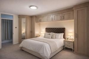 a bedroom with a large white bed with cabinets at Randall Farm Near Brands Hatch Circuit in Fawkham