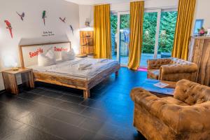 a bedroom with a large bed and two chairs at Seaside-Townhouse in Timmendorfer Strand
