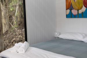 two towels are sitting on a bed in a room at Hill Creek Tiny House 5 by Tiny Away in Perwillowen