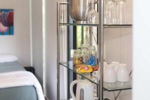 a glass shelf with food and other items in a room at Hill Creek Tiny House 5 by Tiny Away in Perwillowen
