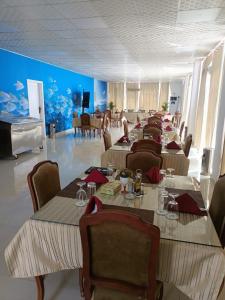 a restaurant with tables and chairs and a large aquarium at Le-Printemps Hotel in Suez
