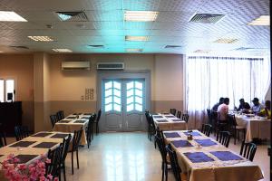a dining room with tables and people sitting at tables at Le-Printemps Hotel in Suez