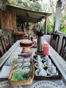 a picnic table with a tray of food and cups and coffee at CHÁCARA dos CHEIROS in Atibaia