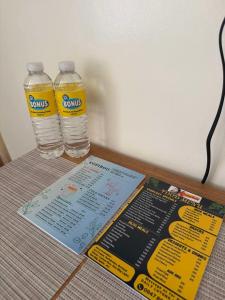 two bottles of water and a menu on a table at Las Fallas Staycation in Santa Rosa
