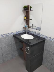 a bathroom with a black counter with a sink at Dptos Ceci in Centenario
