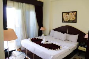 a hotel room with a bed with aulturevisorvisorvisor at Le-Printemps Hotel in Suez