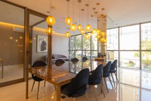 a dining room with a long table and chairs at Studio Lumière Moema in São Paulo