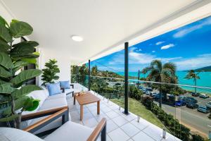an apartment balcony with a view of the ocean at Broadwater Breeze in Airlie Beach