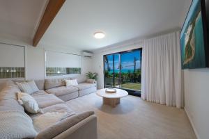 a living room with a couch and a table at Broadwater Breeze in Airlie Beach