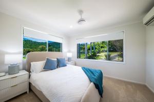 a bedroom with a bed and a large window at Broadwater Breeze in Airlie Beach