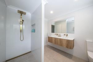 a white bathroom with a sink and a toilet at Broadwater Breeze in Airlie Beach +20 photos