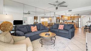 a living room with blue couches and a table at Beachcrest 805 in Santa Rosa Beach