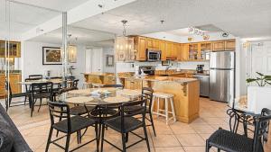 a kitchen with wooden cabinets and a table and chairs at Beachcrest 805 in Santa Rosa Beach