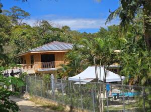a house with a fence in front of it at Casa Las Brisas in Nicoya