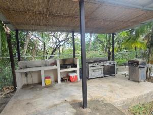 an outdoor patio with a grill and a stove at Casa Las Brisas in Nicoya