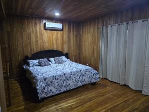 a bedroom with a bed in a room with wooden floors at Casa Las Brisas in Nicoya +40 photos
