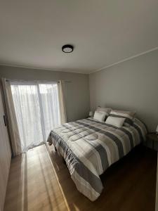 a bedroom with a bed and a large window at Casa Jesy in Frutillar +17 photos